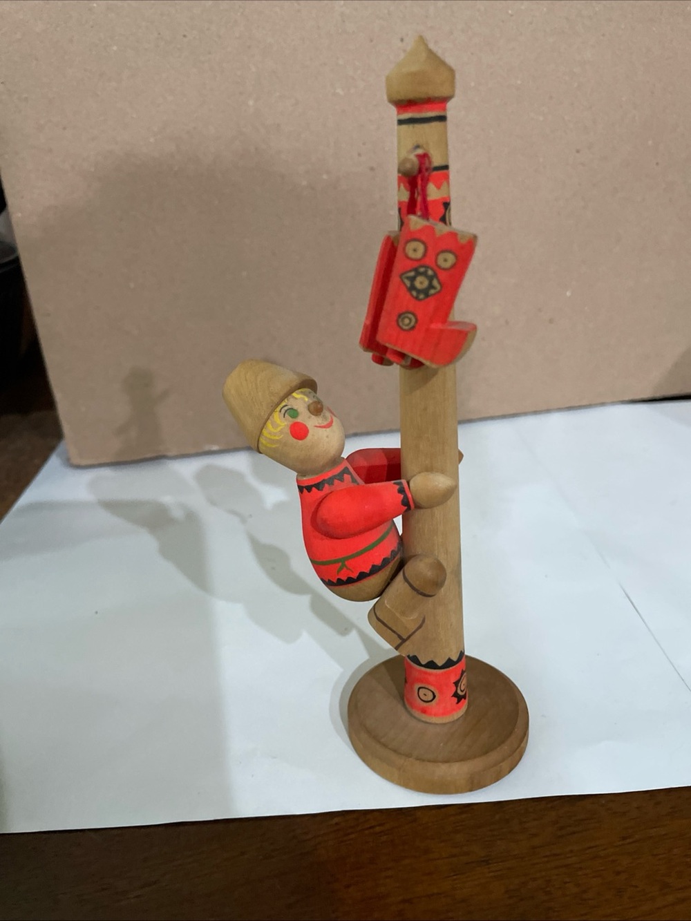 Wooden Figure Climbing Pole Topped With Boots  APMAPKA
